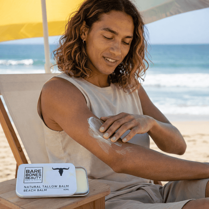 Person applying Bare Bones Beauty Beach Tallow Balm - 40ml on arm at the beach for skin nourishment and protection