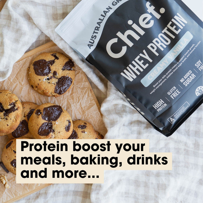 Grass-fed Whey Protein Powder - Creamy Vanilla - 900g by Chief beside freshly baked chocolate chip cookies on parchment paper